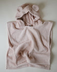 The mushie Bear Poncho Towel, made from soft organic cotton in light pink, is shown laid flat. It features a cozy hood with two rounded bear-like ears, perfect for children.