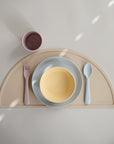 Mushie Dinnerware Fork and Spoon Set: pastel kids’ bowl, plate, cup on placemat.