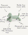 The mushie Dog Figurine Teether, shown in light green silicone, promotes imaginative play, builds fine motor skills, soothes teething (reaching back molars), and is made from 100% food-grade silicone—BPA/BPS/PVC/phthalate free.
