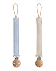 Mushie Linen Pacifier Clip 2-Pack in blue and beige shown on a white background.
