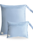 Two mushie Water Resistant Wet Bags in Tradewinds, one large and one small, both with wrist straps and a white label at the bottom left corner, are shown on a white background—ideal for diaper bag storage.