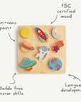 The Mushie Wooden Puzzle features colorful, space-themed pieces—sun, rocket, planets, astronaut, shooting star, UFO—on a square board. Made from FSC-certified wood with non-toxic paint; supports fine motor skills and language development.