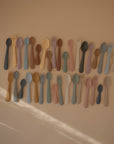 The mushie Silicone Toddler Starter Spoons feature colorful, pastel tones and are arranged neatly in rows—perfectly designed to encourage independent feeding for babies and toddlers.
