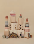The mushie Coin & Tube Sorting Set is displayed against a beige background, offering a visually appealing educational toy that encourages fine motor skill development.