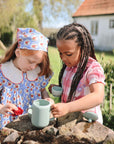 Two young girls host an outdoor tea party with the Mushie Silicone Tea Play Set.