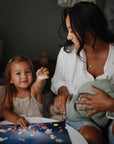 mom and kids playing with sticker book