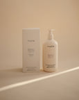 Mushie Baby Shampoo & Body Wash for delicate skin in beige bottle and box on neutral background.