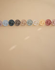 Lifestyle image Moon Silicone Frigg pacifiers all in a row.