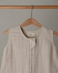 Lifestyle image of a Mushie Sleep Bag in Fog on a hanger.
