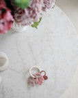 A mushie Fairy Teething Ring with a marble table, floral arrangement, and candles for sensory play.