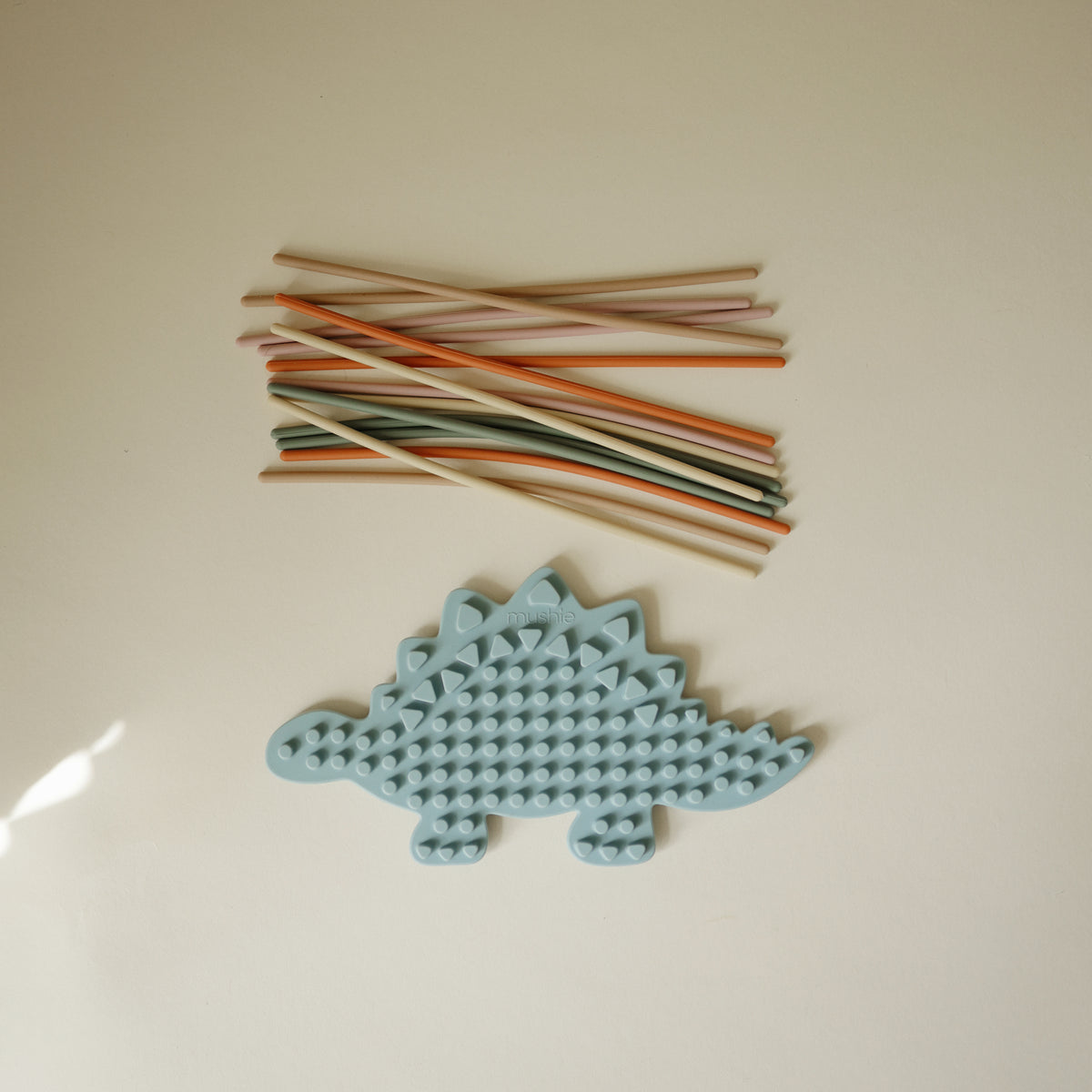 Mushie Silicone Sensory Toy and colored straws for fidget or fine motor play fun.