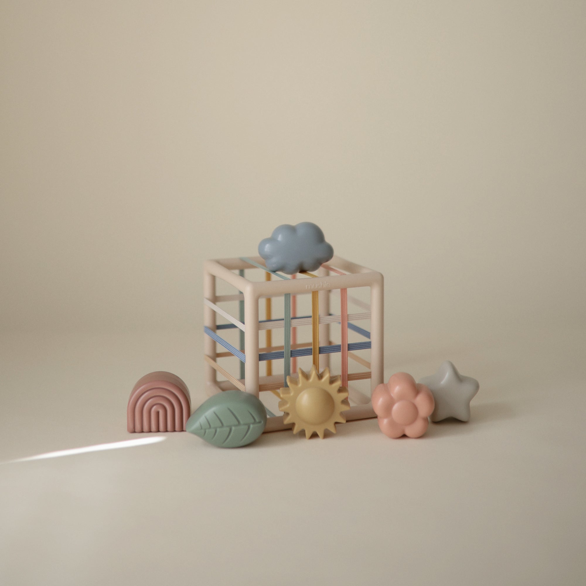 The mushie Elastic Shape Sorter encourages tactile play and builds fine motor skills.