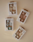 Four boxes of FRIGG Baby's First Pacifier Moonlight Sailing (Cream) 4-Pack are arranged on a neutral surface, each showing two silicone pacifiers for ages 0–6 months with Danish branding.