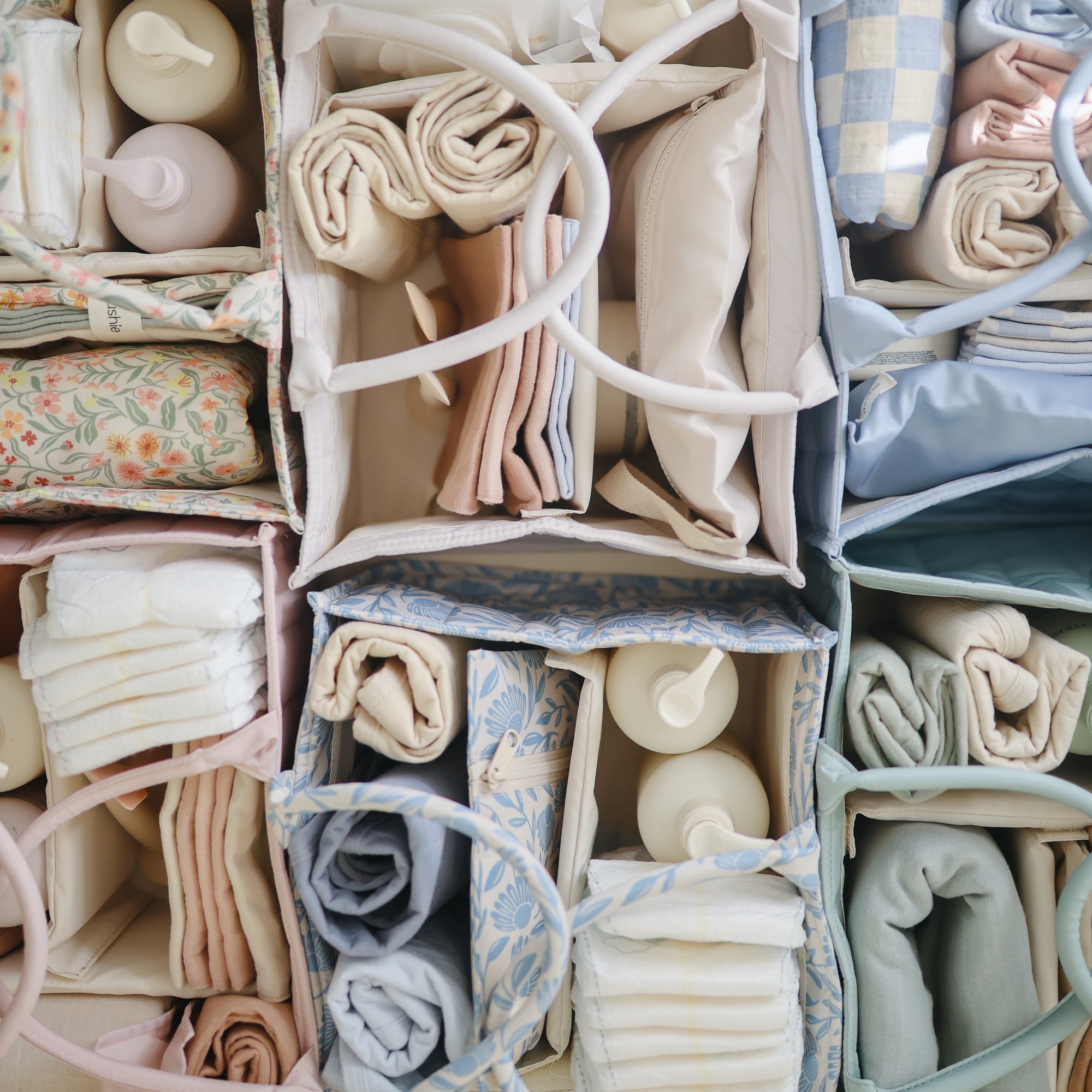 Lifestyle image of an organized collection of mushie diaper caddies in a grid pattern.