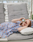 Young girl enjoys imaginative play with mushie Kaleidoscopes while lying on a swing bench.