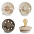The FRIGG Natural Rubber Pacifier 4-Pack by FRIGG features four pacifiers in neutral tones, each with a unique design—smooth geometric pattern, rope-like edges, vents, and handles.