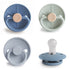 The FRIGG Silicone Pacifier 4-Pack in Skyline Serenity features four medical-grade silicone pacifiers with round shields and varied textured edges—smooth and rope-like—arranged on a white background.