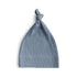 The mushie Ribbed Baby Beanie in light blue, made from organic cotton with a cute knotted top, is shown laid flat on a white background.