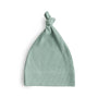 The mushie Ribbed Baby Beanie is a light green, rib knit hat with a top knot, made from organic cotton and shown against a white background.