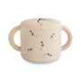 The mushie Snack Cup is a beige silicone cup with two handles and a flexible, spill-proof lid, featuring adorable bee illustrations—perfectly sized for toddlers’ hands.