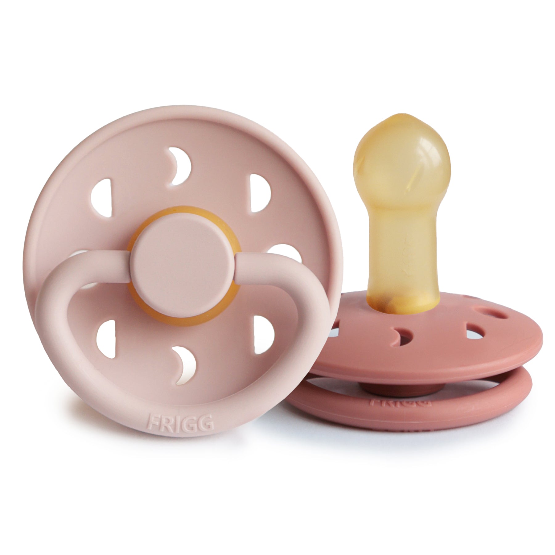 Two FRIGG Moon Natural Rubber Pacifiers, pink, one upright and one lying down.