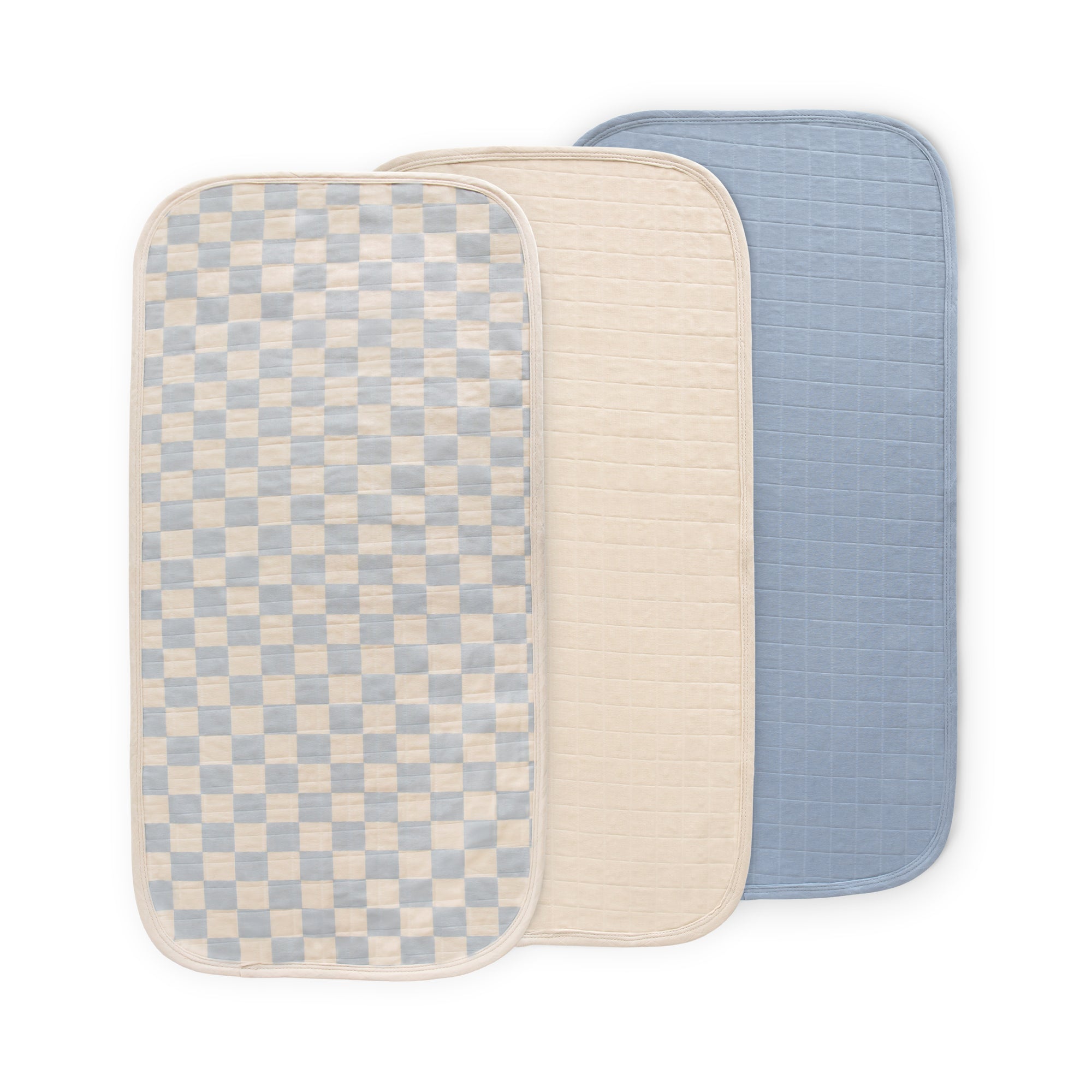 Mushie Changing Pad Liners: three muslin rectangles—checkered, beige, and blue, overlapping.