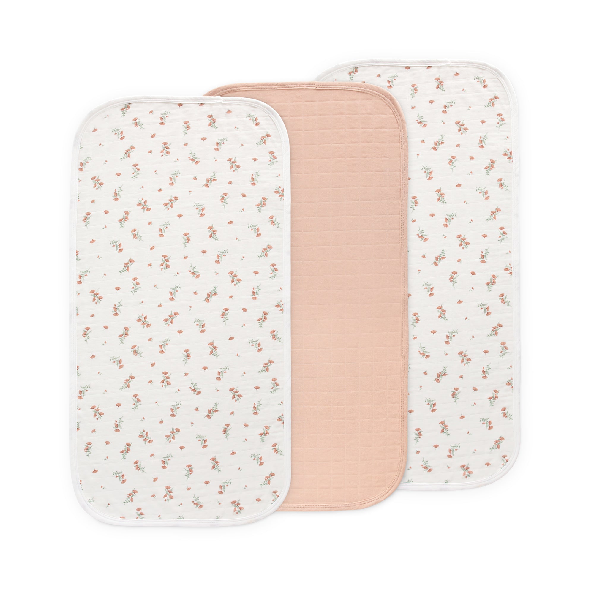 Three Mushie Changing Pad Liners—two floral, one solid pink in the center—organic cotton.