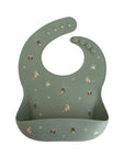 Mushie Silicone Baby Bib: green, festive print, adjustable strap, easy to clean.