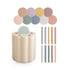 The mushie Coin & Tube Sorting Set features a beige scalloped sorter with a mint green lid, ten pastel lids, and matching straws in pink, yellow, green, blue, purple, and white—perfect for developing fine motor skills.
