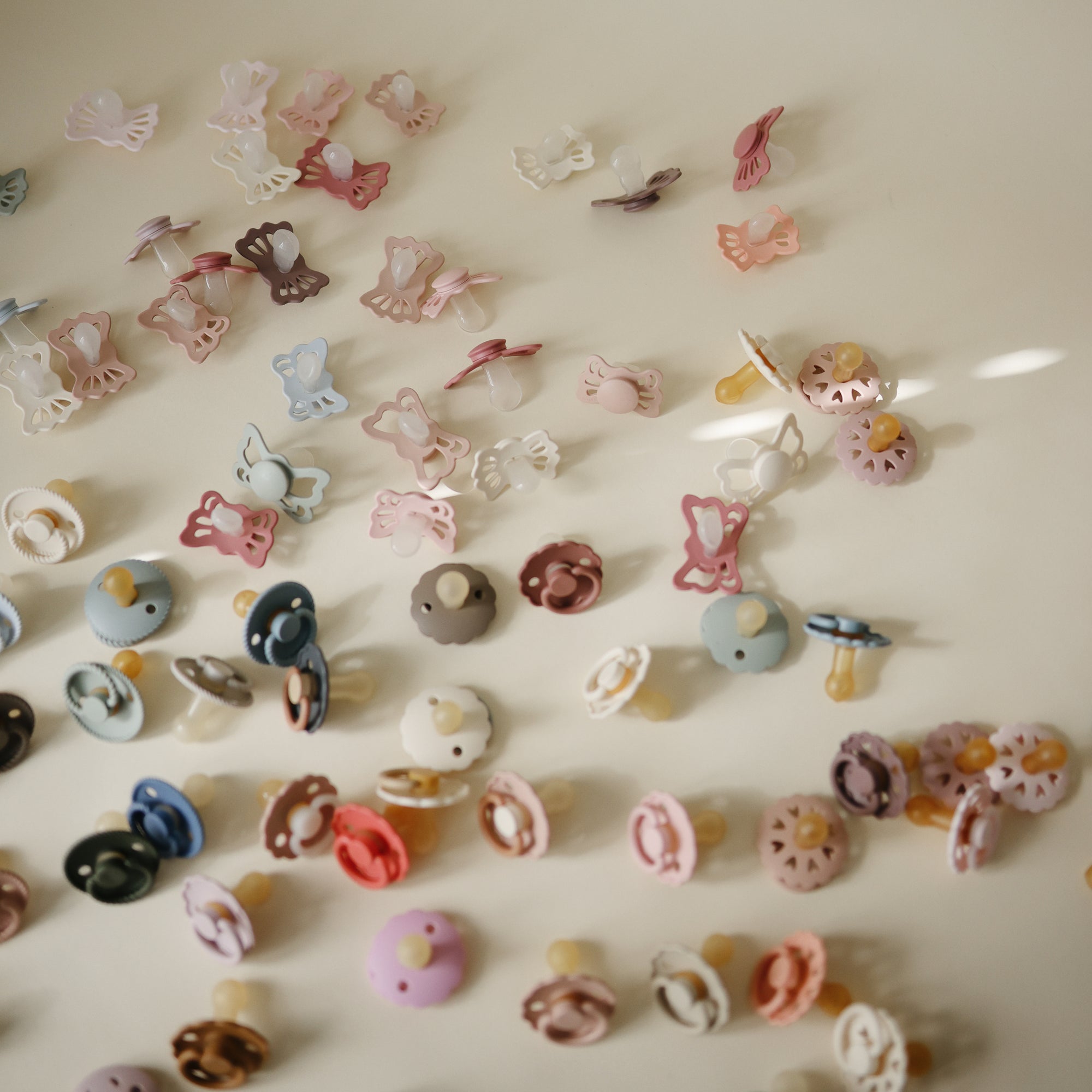 FRIGG Daisy Night Natural Rubber Pacifier 2-Pack and clips arranged on a light surface.