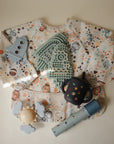 Mushie Silicone Sensory Toy for fine motor play on beige background with space-themed items.