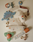 Mushie Silicone Sensory Toy: dinosaur-themed beige baby teething and feeding accessory.