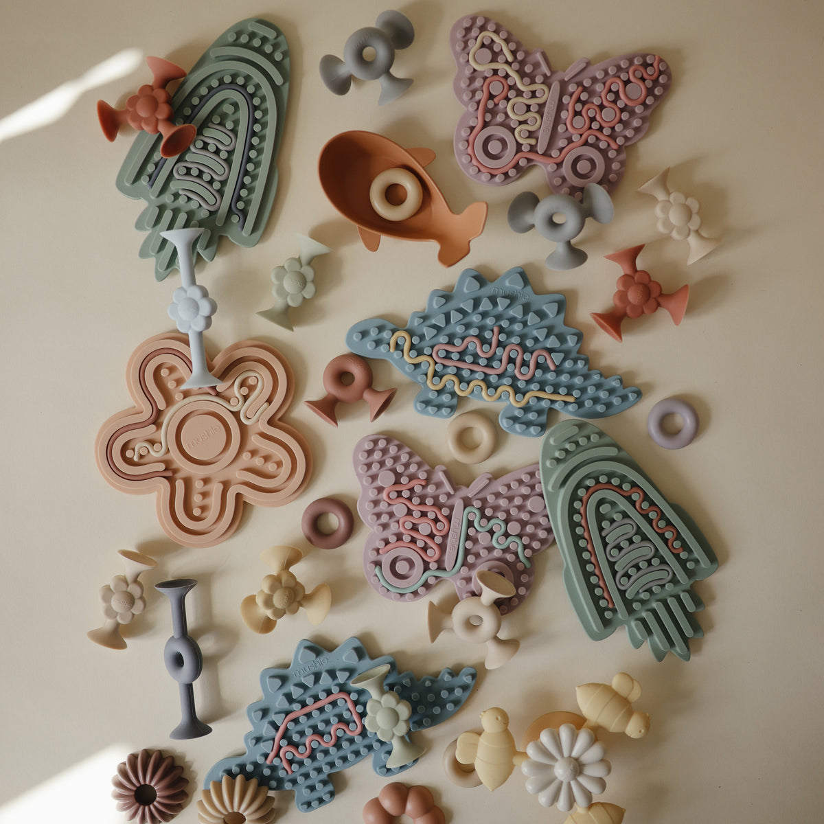 Mushie Silicone Sensory Toy: bird, butterfly &amp; flower shapes for fine motor play.