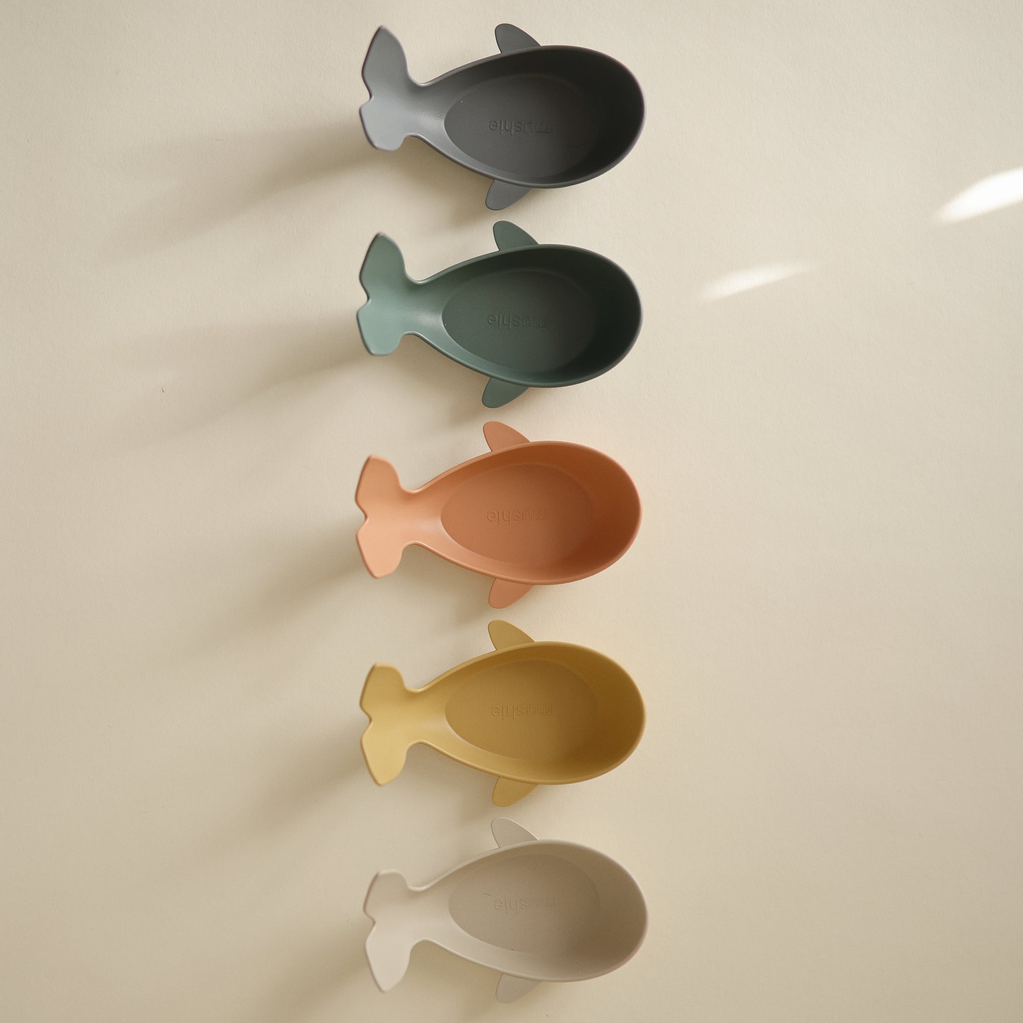 Mushie Whale Bath Stackers: five colorful, whale-shaped toys stacked on a light background.