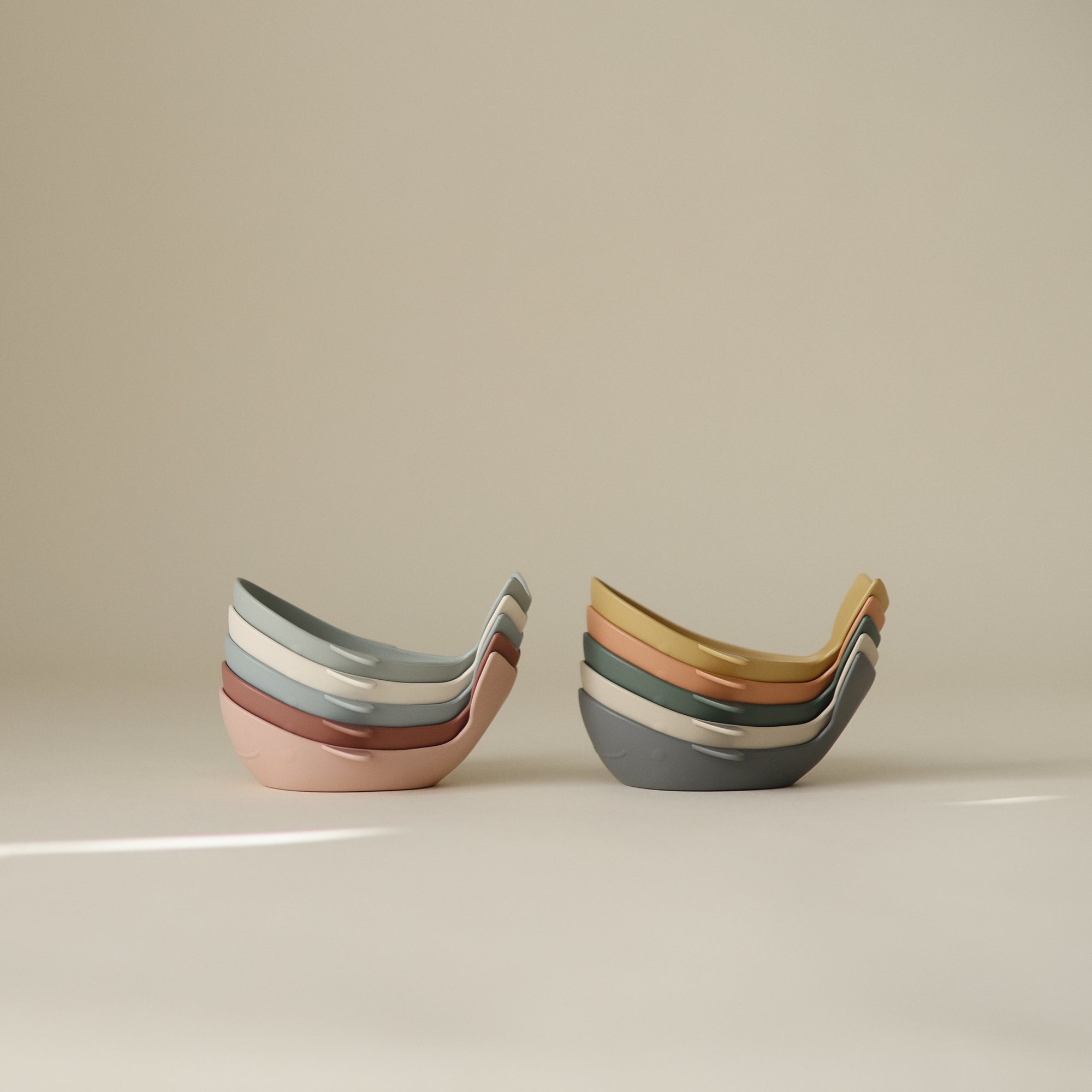 Mushie Whale Bath Stackers in pastel colors, shown stacked on a neutral background.