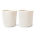 Two mushie Dinnerware Cups sit side by side on a white background. These non-toxic, plain white ceramic cups are cylindrical with smooth surfaces, lacking handles or decorations.