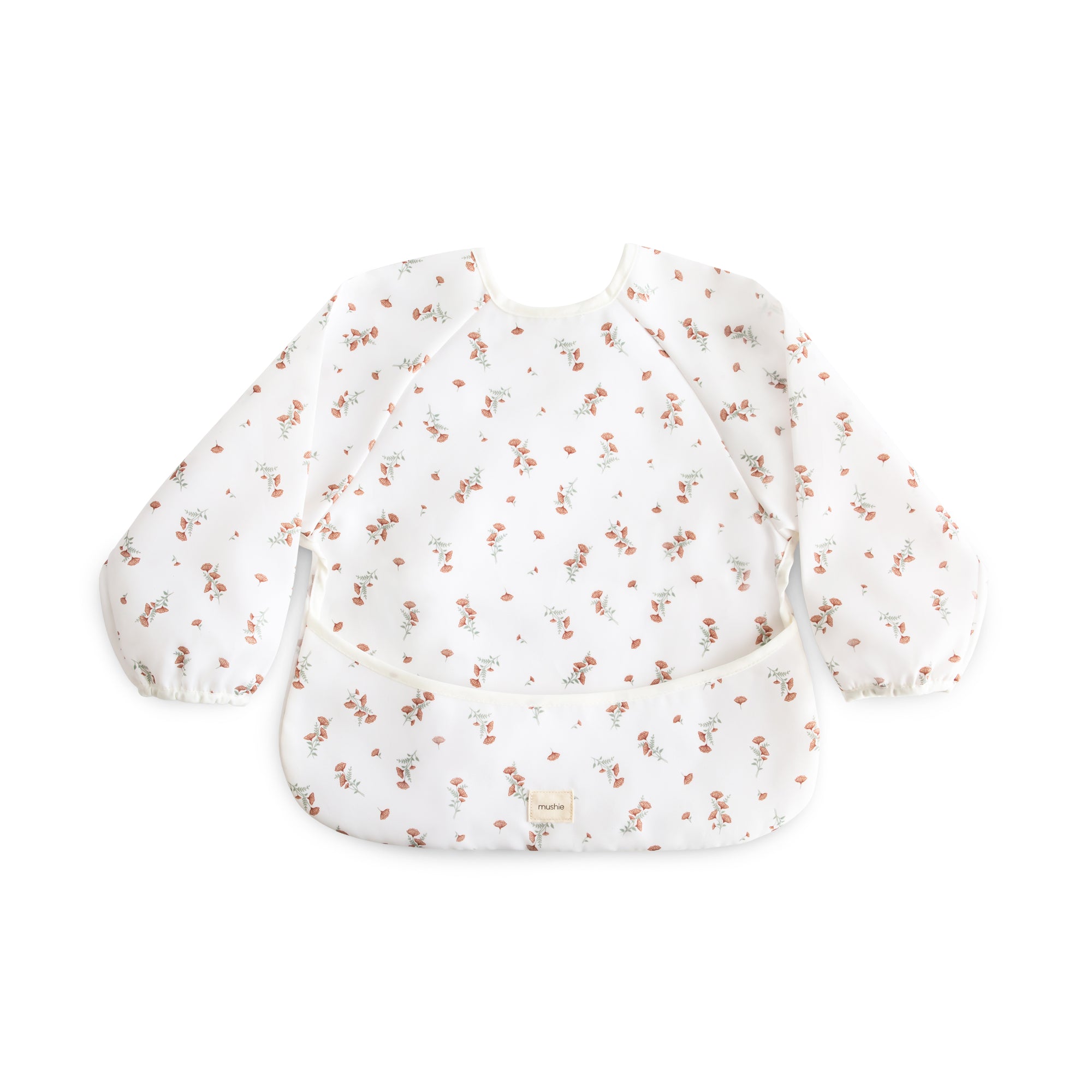 Mushie Long Sleeve Bib: white, water-resistant, floral print, pocketed baby bib.