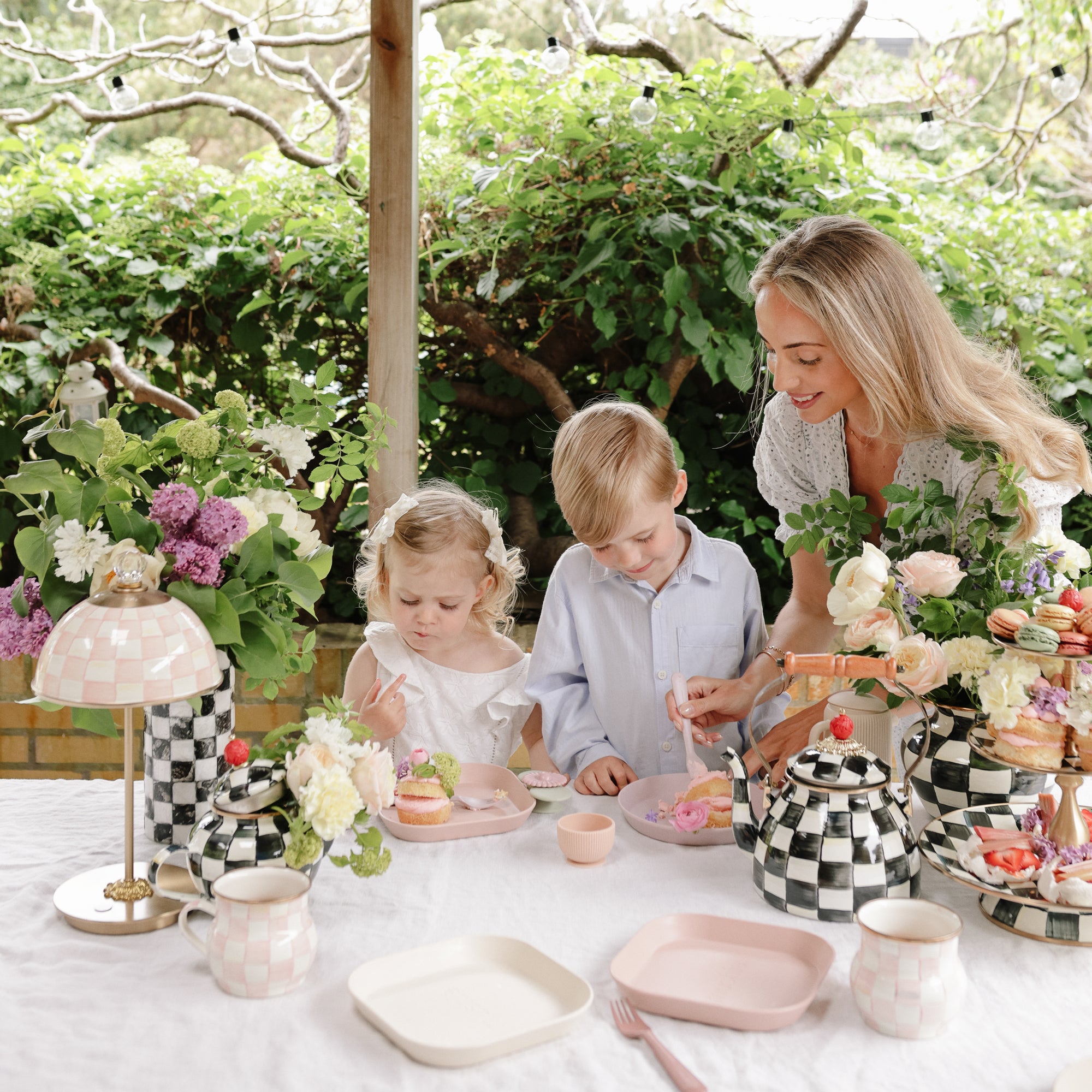 A woman and kids enjoy cake outdoors with mushie Square Dinnerware Plates.