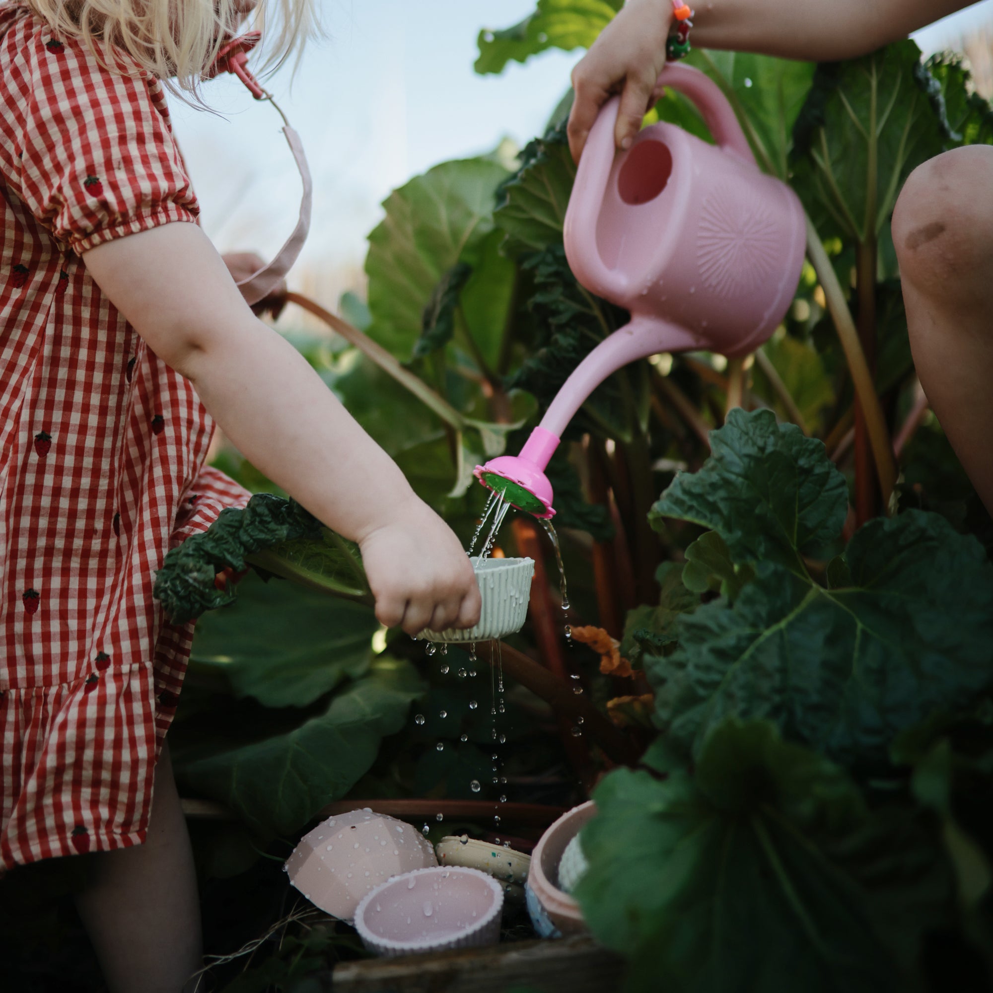 Two kids use mushie's Mix and Match Toy, building fine motor skills while playing outside.
