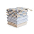 A neatly folded stack of six mushie Muslin Cotton Washcloths in soft blue, cream, and beige, featuring a mix of solid and checkered patterns, displayed on a white background.