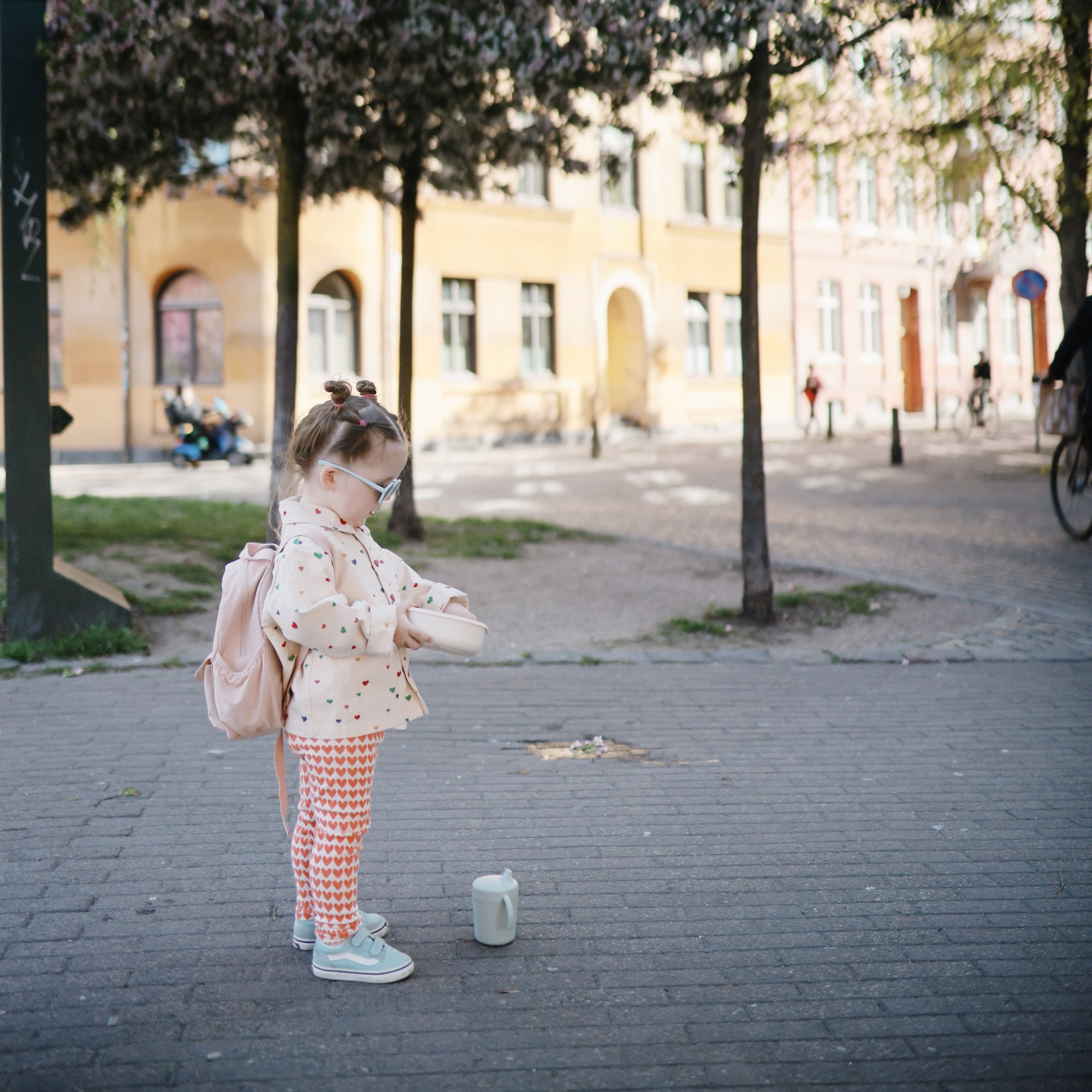 Young girl with glasses carries a mushie Lunchbox with built-in compartments and non-toxic materials.