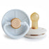The FRIGG Little Viking Natural Rubber Pacifier 2-Pack features light blue and beige pacifiers with round shields and tan natural rubber nipples, made in Denmark for comfort and quality.