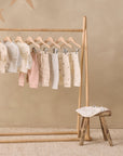 Rylee + Cru Drawstring Pant Cloud Stripe hangs on rack, stool near, beige background.