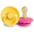 The FRIGG Rope/Daisy Natural Rubber Pacifier 2-Pack (Sunflower/Fuchsia, 6-18 Months) includes a yellow pacifier with a rope-style handle and a pink one with a daisy base—both with natural rubber nipples—for your baby essentials.
