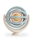 Mushie Suction Spinner Ball: pastel toy with interlocking rings and a yellow ball.