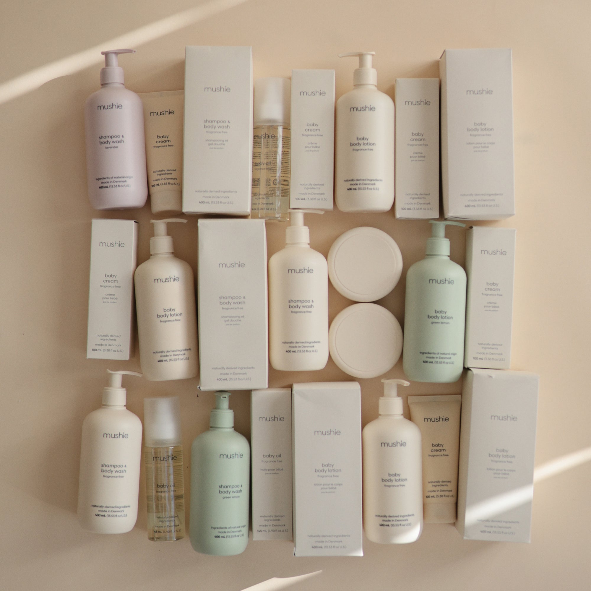 Mushie Baby Body Lotion with natural ingredients displayed in assorted bottles and boxes.