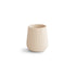 The mushie Silicone Starter Cup, a beige ribbed baby training cup with a rounded base, is shown on a white background.