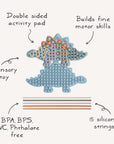 Mushie Silicone Sensory Toy: blue dinosaur shape with labeled features for fine motor play.