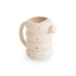 The Mushie Silicone Watering Can is a beige, rounded can with a chunky, coiled design, multicolored speckles, a large handle, and a small spout—perfect for water play or as a whimsical bath toy.