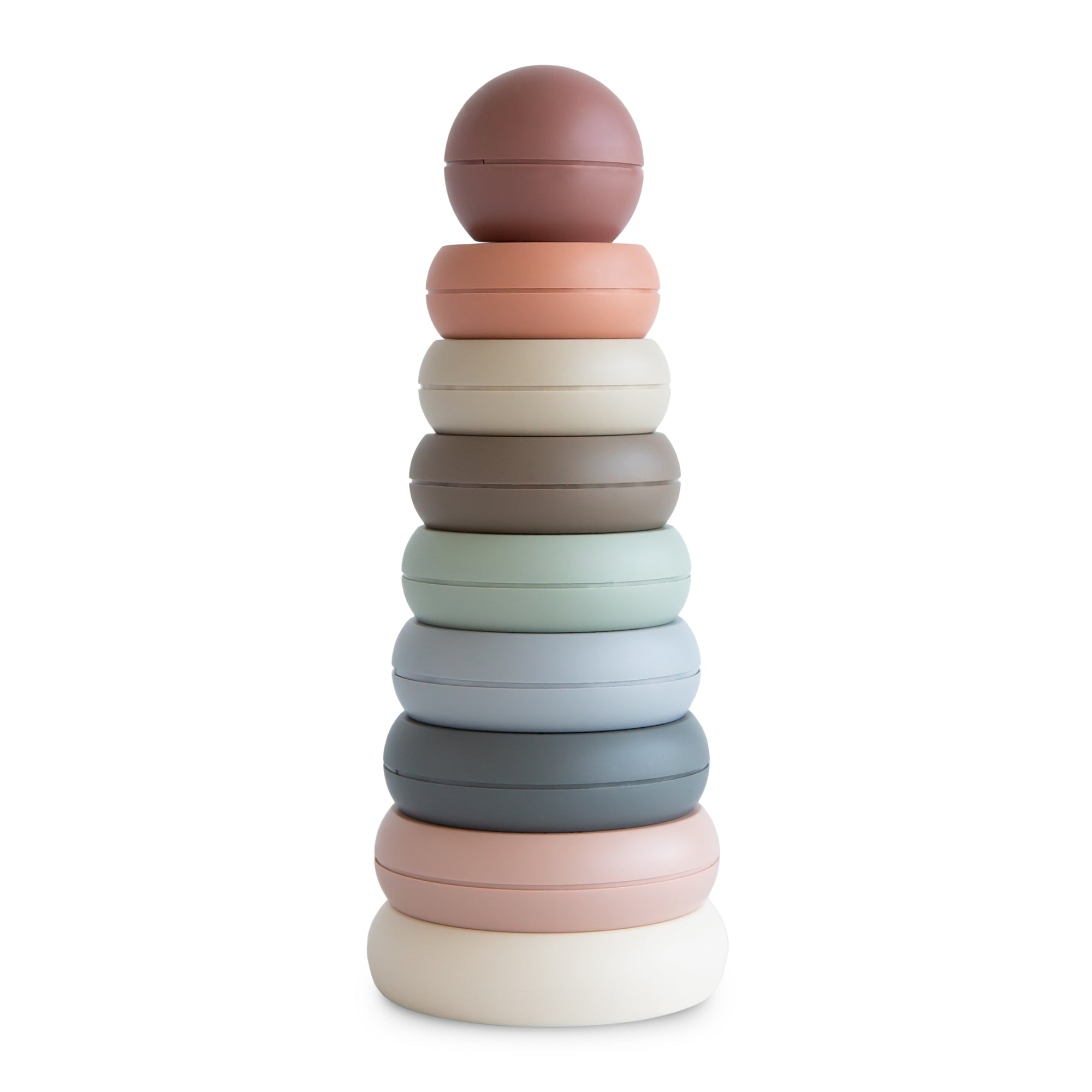 The mushie Stacking Rings Toy features pastel-colored, non-toxic, donut-shaped rings in muted shades, stacked from largest to smallest with a round ball on top.